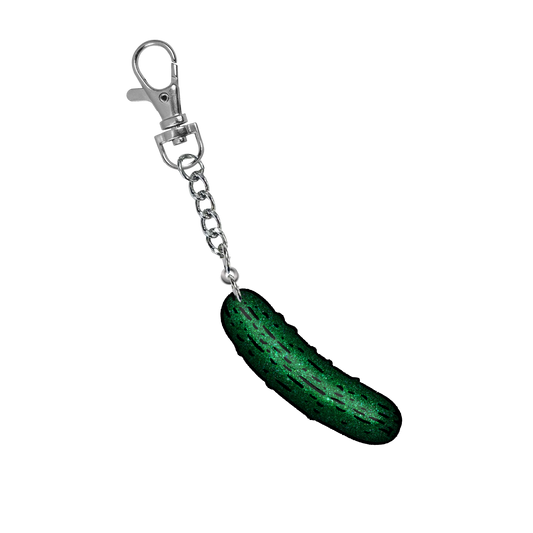A sparkly green pickle charm keychain, from the latest album from Ashnikko, Smoochies.